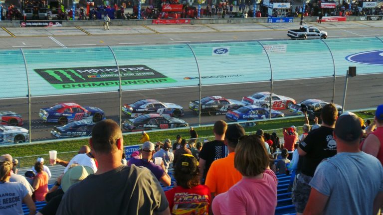 Fans watching cars race at Homestead-Miami Speedway during Homestead NASCAR Packages weekend