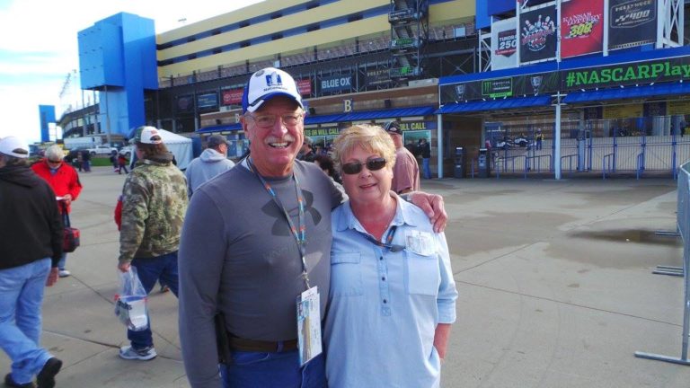 Couple smiles outside the grandstand entrance at Kansas Speedway during a NASCAR weekend.