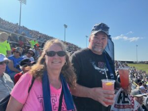 Couple enjoys cold drinks in the Iowa Speedway grandstands during Iowa NASCAR Packages and Iowa NASCAR Ticket Packages weekend.