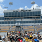 Fans gather on the frontstretch at Iowa Speedway with the tower in the background, part of Iowa NASCAR Ticket Packages.