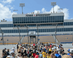Fans gather on the frontstretch at Iowa Speedway with the tower in the background, part of Iowa NASCAR Ticket Packages.