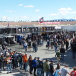 Fans walking through the Neon Garage infield area at Las Vegas Motor Speedway during NASCAR weekend