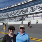RaceAway Daytona NASCAR ticket package guests standing on the frontstretch at Daytona International Speedway during pre-race activities
