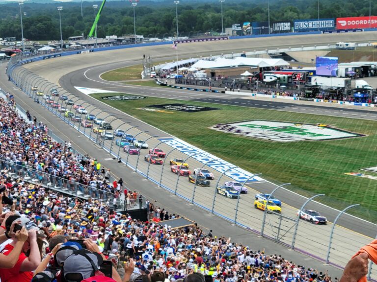 Cars racing at Nashville Superspeedway during a packed NASCAR event