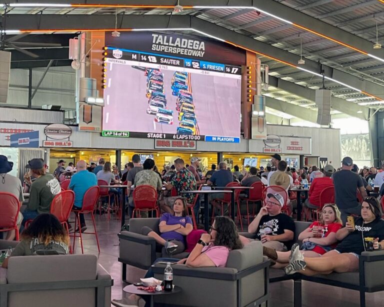 Fans relaxing in the Talladega Superspeedway infield club while watching live NASCAR racing on the big screen.