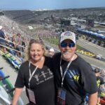 RaceAway Hospitality Daytona NASCAR packages guests smiling in the grandstands at Daytona International Speedway during the Daytona 500