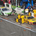 NASCAR pit crews service race cars on pit road at Daytona International Speedway during the Daytona 500