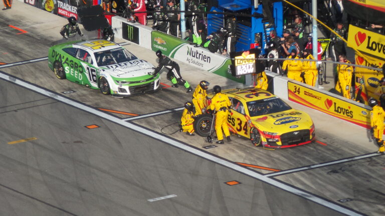 NASCAR pit crews service race cars on pit road at Daytona International Speedway during the Daytona 500
