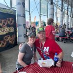 Couple seated at Iowa Speedway enjoying food and drinks before the NASCAR race as part of their RaceAway Hospitality weekend for the Iowa Corn 350.