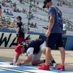 A RaceAway Nashville NASCAR ticket package guest signing the start/finish line at Nashville Superspeedway