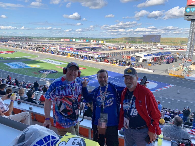 Three race fans enjoying the view from the grandstands at Charlotte Motor Speedway