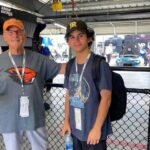 Two NASCAR fans standing inside the Talladega Superspeedway Garage Experience area during race weekend with RaceAway.