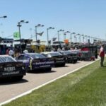NASCAR race cars lined up on pit road at Kansas Speedway ahead of the race