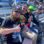 Group of friends cheering from the grandstands at Martinsville Speedway with a Martinsville NASCAR Ticket Package for a short-track weekend