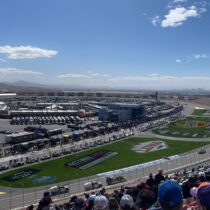Wide view of Las Vegas Motor Speedway with NASCAR Cup Series cars on track and packed grandstands