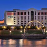 Embassy Suites Des Moines Downtown lit up at night with Iowa State Capitol dome in the background.