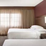 Spacious double-bed suite at Embassy Suites Des Moines Downtown, perfect for Iowa NASCAR Packages guests.