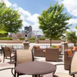 Riverside patio at Embassy Suites Des Moines Downtown with outdoor seating for Iowa NASCAR Tickets fans.