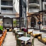 Embassy Suites Orlando North atrium dining space with booth seating and modern lighting, ranked among top Daytona 500 hotels.