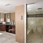 Luxury bathroom with double vanity and walk-in shower at Embassy Suites Des Moines Downtown, ideal for Iowa NASCAR Packages and Tickets guests.
