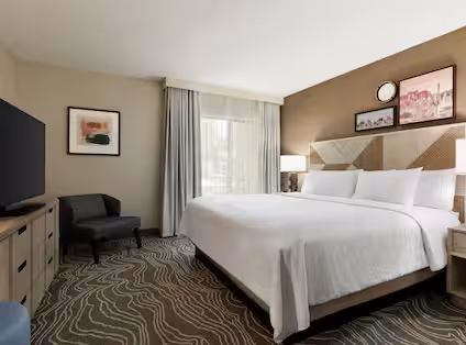 Spacious guest room with a king bed and modern décor at the Embassy Suites Phoenix–Tempe.