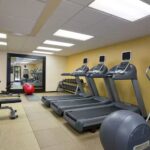 Modern fitness center with treadmills and weights at Embassy Suites Phoenix – Tempe.