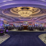 Vibrant casino floor with slot machines and chandeliers at Park MGM, featured in our Las Vegas NASCAR Hotels and Las Vegas NASCAR Ticket Packages.
