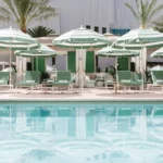 Resort-style pool with green-and-white cabanas at Park MGM, part of our Las Vegas NASCAR Hotels.