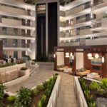 Atrium view inside Embassy Suites Atlanta Airport hotel with greenery and modern seating areas