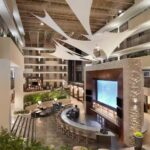 Atrium bar and lounge area inside Embassy Suites Atlanta Airport with modern architecture and hanging ceiling sails
