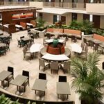 Atrium dining area at Embassy Suites Atlanta Airport with circular seating and surrounding greenery