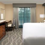 King suite bedroom at Embassy Suites Atlanta Airport with desk and large window