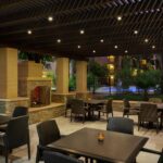 Outdoor patio dining area with fireplace at Embassy Suites Phoenix – Tempe.