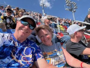 Two RaceAway guests smile for a selfie in the Daytona International Speedway grandstands during the Daytona 500.