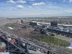 Wide view from the grandstands overlooking the packed infield crowd and frontstretch at Daytona International Speedway during the 2026 Daytona 500.