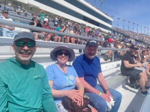 Three RaceAway guests sit in the grandstands at Las Vegas Motor Speedway during a NASCAR race weekend.