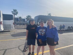 Three RaceAway guests pose near the motorcoach parking area outside Las Vegas Motor Speedway during a NASCAR race weekend.