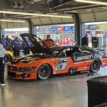 The No. 6 Consumer Cellular NASCAR Cup Series car sits in the garage at Phoenix Raceway during the 2026 Straight Talk Wireless 500 with crew members working nearby.