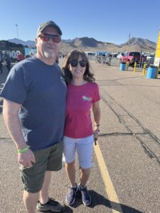 RaceAway guests pose on the Phoenix Raceway concourse during the 2026 Straight Talk Wireless 500 with desert mountains in the background.