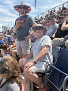 Two RaceAway guests pose in the grandstands at Talladega Superspeedway during a NASCAR weekend.
