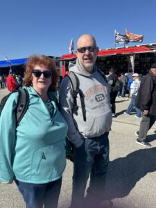 Two RaceAway guests pose for a photo at Kansas Speedway during the 2026 AdventHealth 400 weekend.
