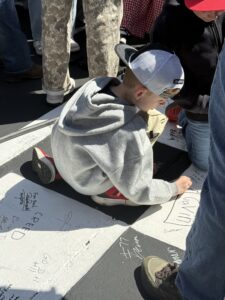 A young RaceAway guest kneels on the track surface at Martinsville Speedway during the 2026 Cook Out 400 weekend.