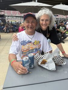 Two RaceAway guests enjoy food and drinks in a hospitality area at Talladega Superspeedway.