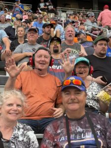 A group of RaceAway guests smiles and waves from the grandstands at Nashville Superspeedway during the 2026 Cracker Barrel 400.