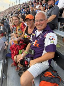 Three RaceAway guests sit together in the grandstands at Nashville Superspeedway during the 2026 Cracker Barrel 400.