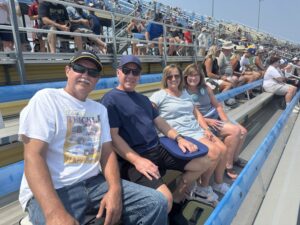 Four RaceAway guests sit together in the grandstands at Iowa Speedway during the 2026 Iowa Corn 350.