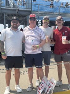 Four RaceAway guests pose near the grandstands at Iowa Speedway during the 2026 Iowa Corn 350 weekend.