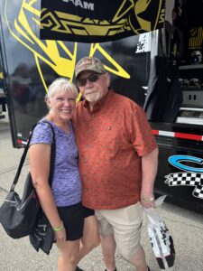 Two RaceAway guests pose near a merchandise hauler at Iowa Speedway during the 2026 Iowa Corn 350 weekend.