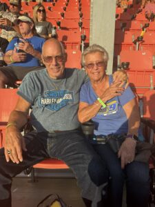 Two RaceAway guests smile from their seats in the grandstands at Bristol Motor Speedway during the 2026 Bass Pro Shops Night Race.