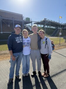 Four RaceAway guests pose outside Talladega Superspeedway during the October 2026 YellaWood 500 weekend.